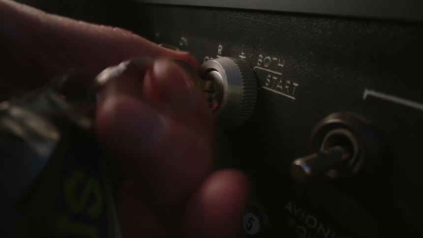 A person turns the ignition key of an airplane