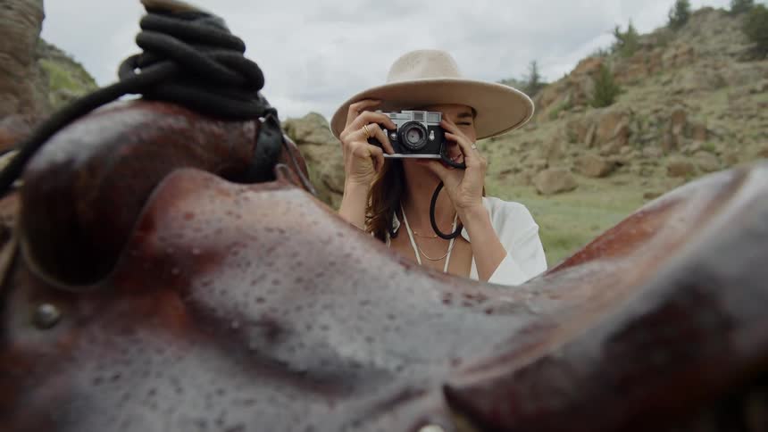 Woman next to a horse taking pictures with a vintage camera