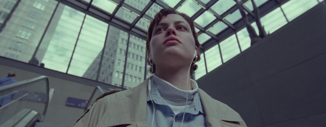 Portrait of a woman descending the escalator of a building