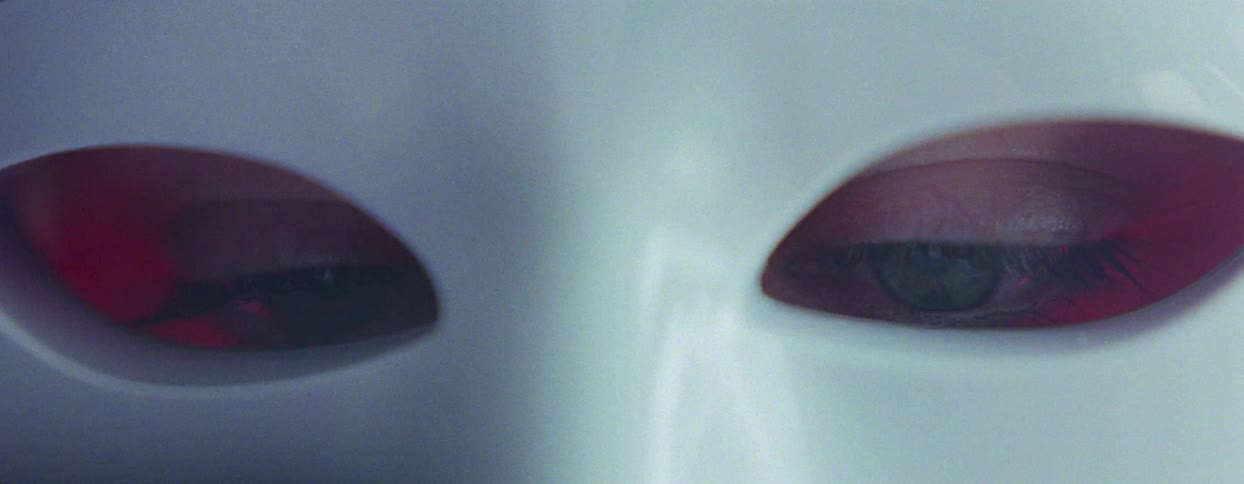 A persons eyes are shown through two holes in a white mask