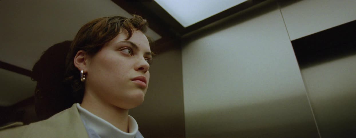 Woman looks around while waiting in an elevator