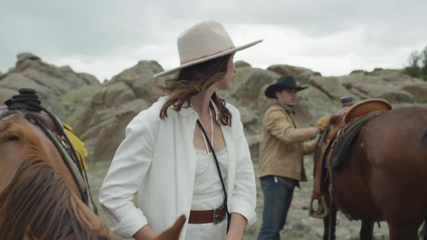 A man and woman get off their horses