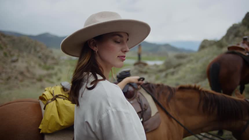 A woman is standing by her horse