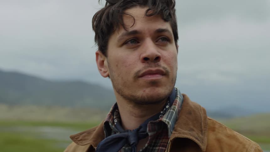 Portrait of a man taking off his hat running his hand over his face and putting his hat back on while standing in a natural setting