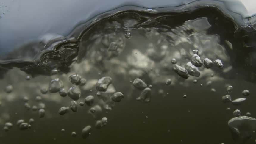 Close up of river water with air bubbles flowing
