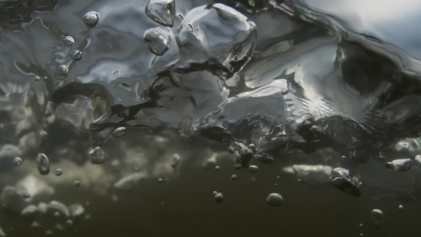 Closeup of murky churning rippling water flowing during the day