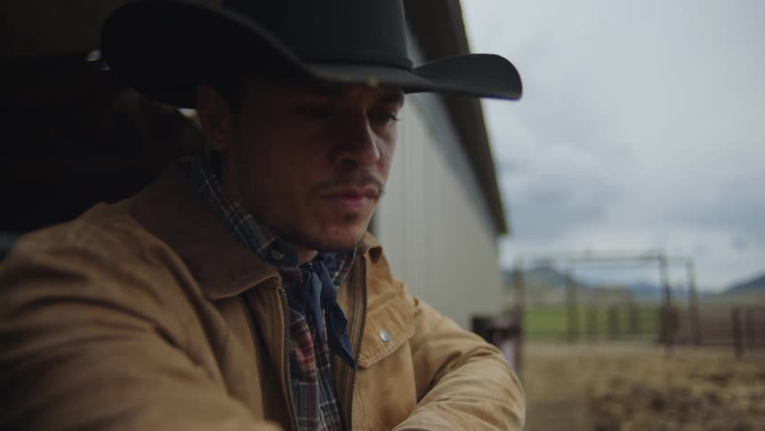 Portrait of a cowboy on a ranch holding grass