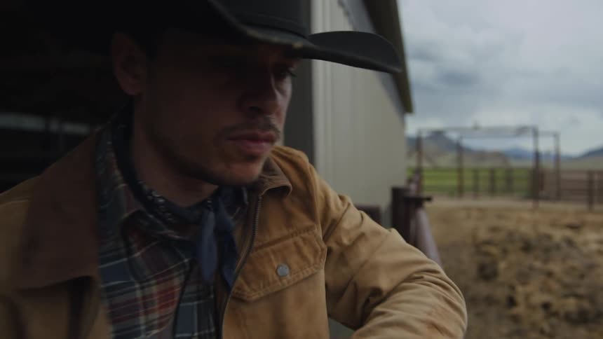 Cowboy in a barn next to animals