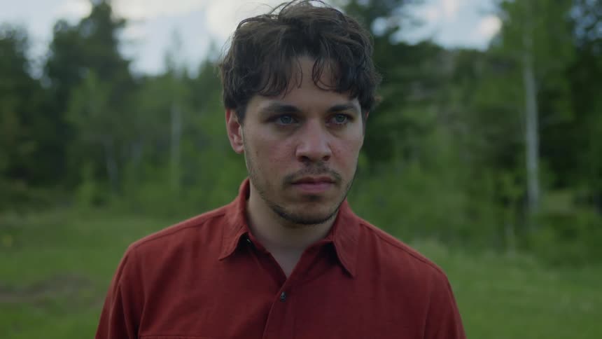 A man thinks and looks angry outdoors before walking away