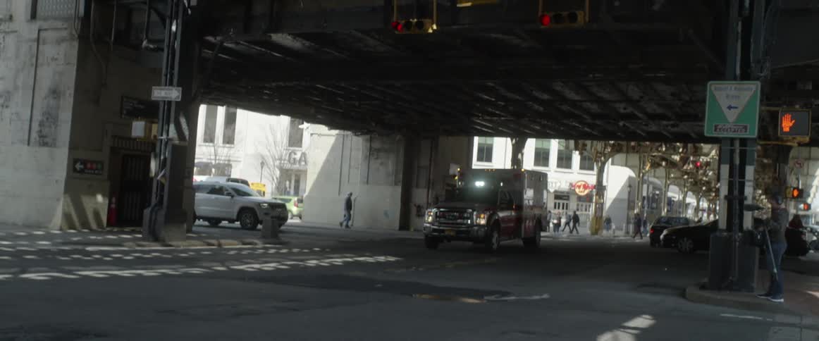 An ambulance is driving through an intersection of a city street