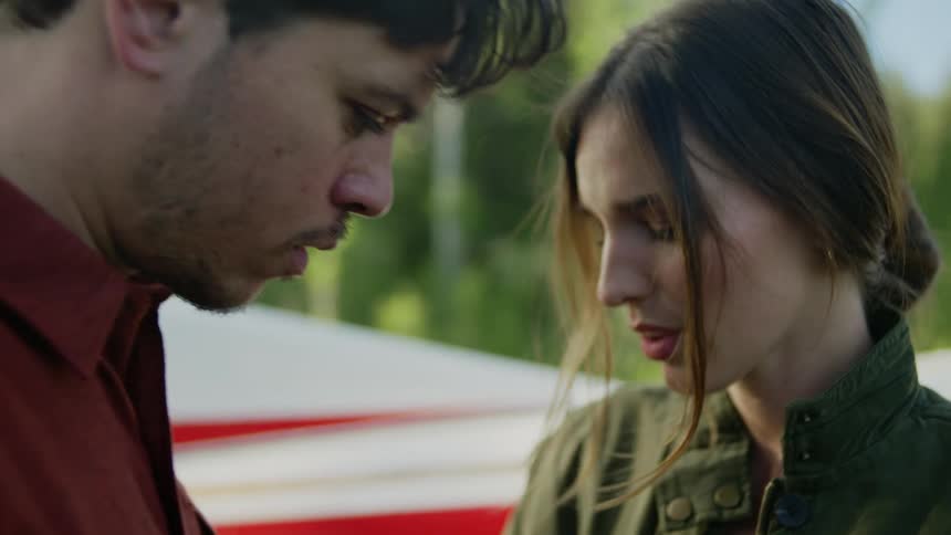 A young man and woman are hugging and saying goodbye and then the woman gets into a small white singleengine plane and closes the door