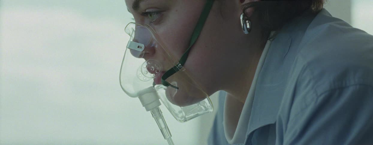 A young woman is wearing a traditional breathing apparatus and mouth and she is closing her eye and slowly opening it