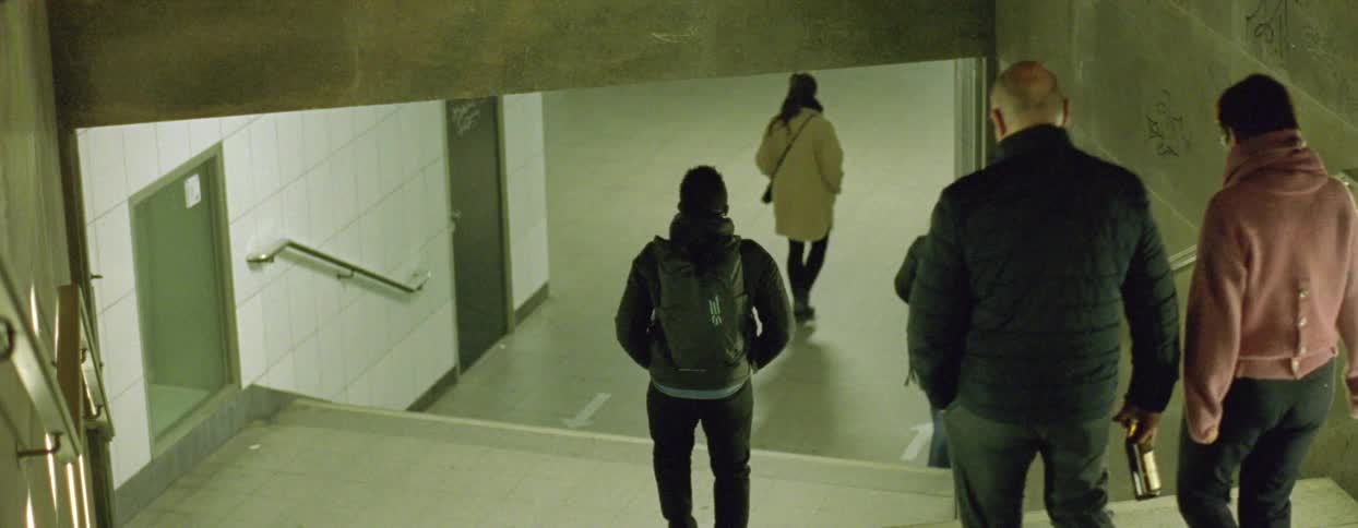 People walking down stairs to walk into a subway station