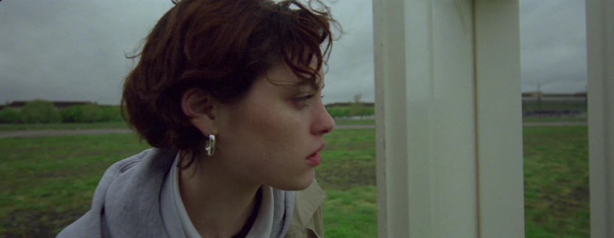 Woman opening a door in an empty field and walking in