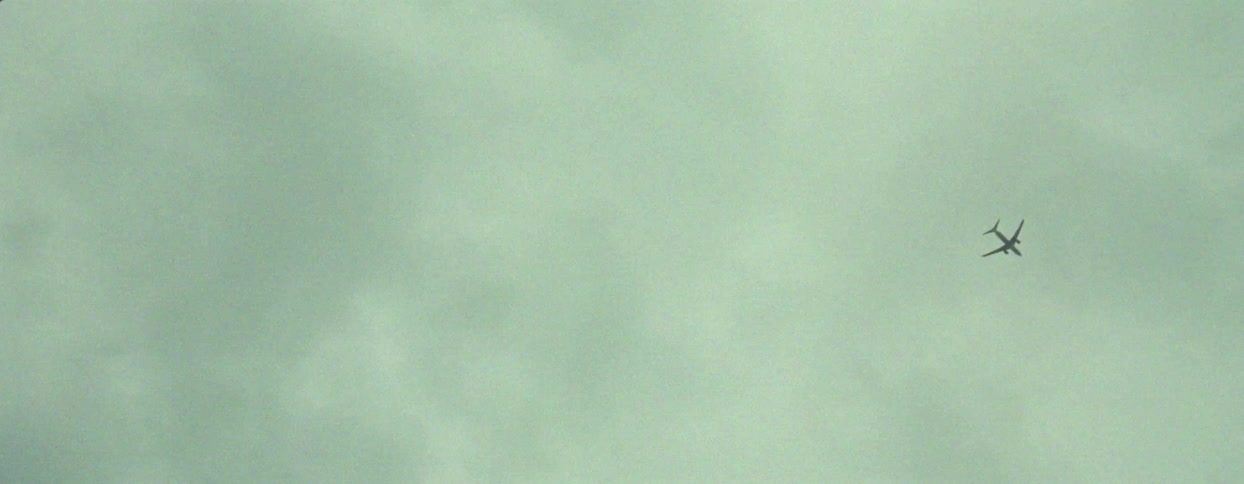 View of a cloudy sky with a plane flying by