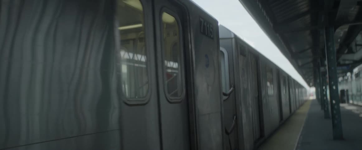 Train traveling slowly past a railroad station