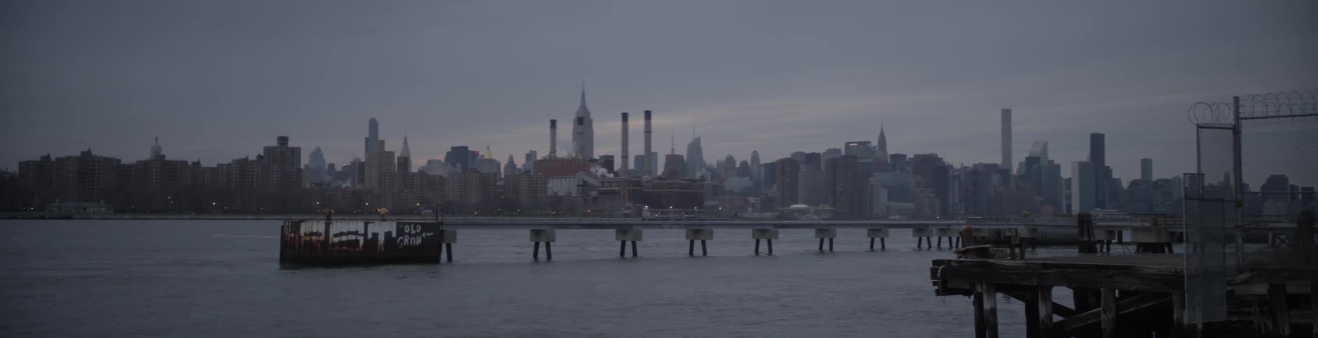 Bridge spanning a river with a large city in the background