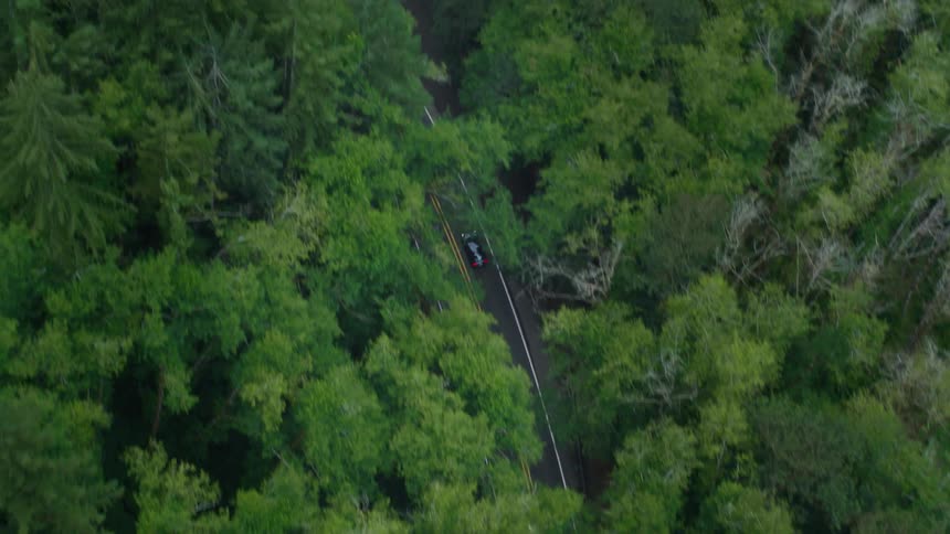 Traffic moves along a highway next to a river in a remote area