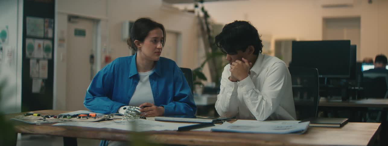 A teacher is talking with a student at the desk