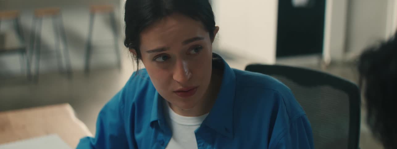 A woman is talking with a coworker in the office
