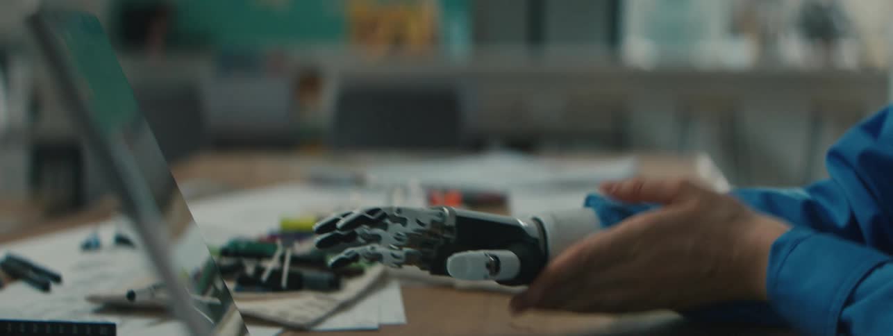Close up of a person wearing a robotic prosthesis hand with metal components