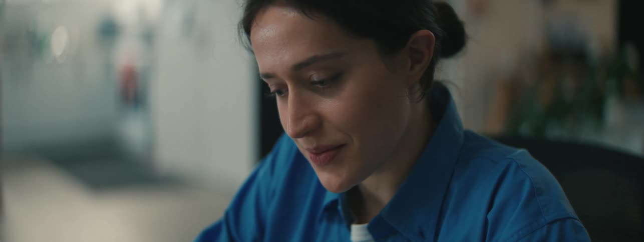Close up of the face of a woman wearing a blue top