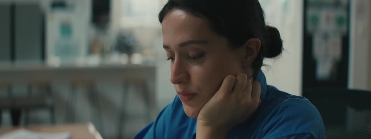 A woman resting her face on her hand in a contemplative manner
