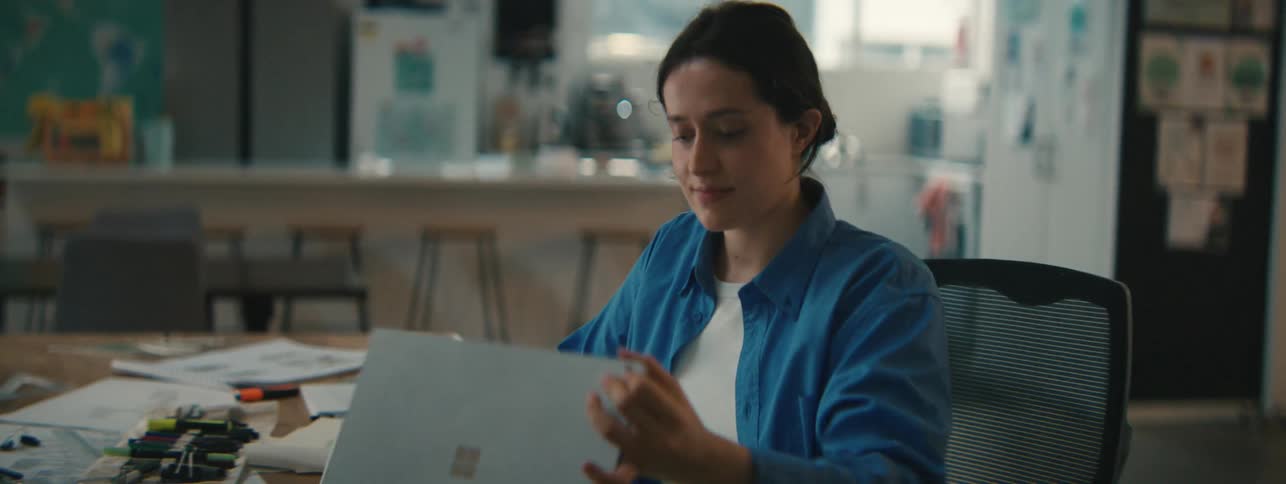 Woman sitting at a table and closing her laptop