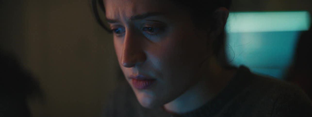 A white woman looks sad as she reads a computer screen