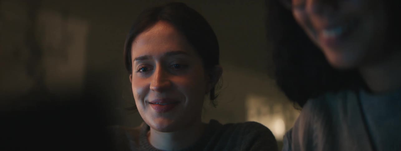 Portrait of two women in a lowlit room looking at a screen
