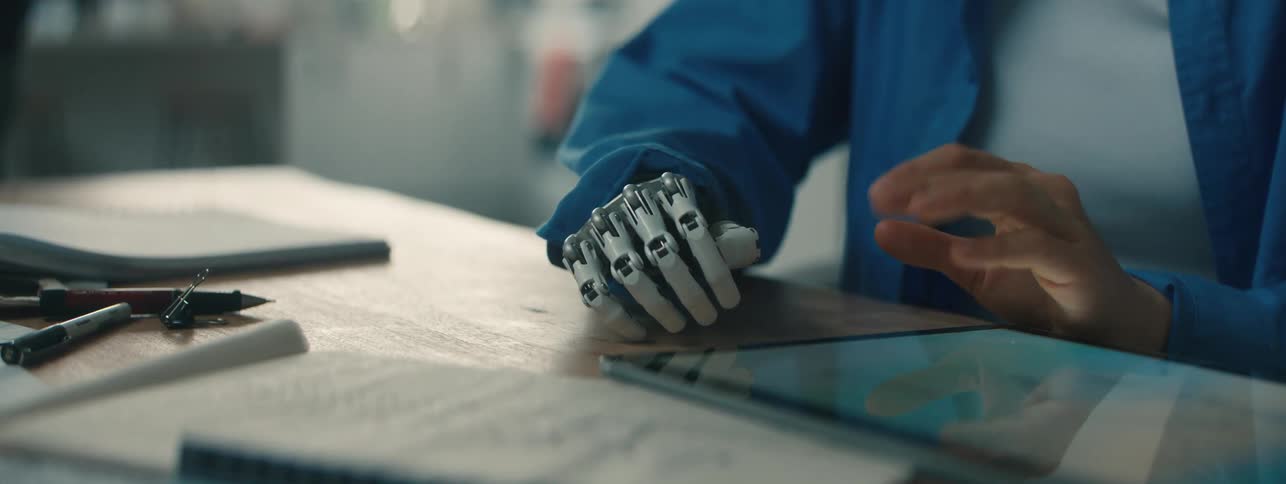 Woman with a prosthetic limb points items out on a tablet while sitting in an office