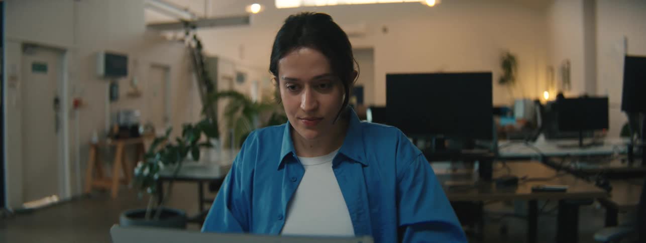 A woman is using a laptop at the desk