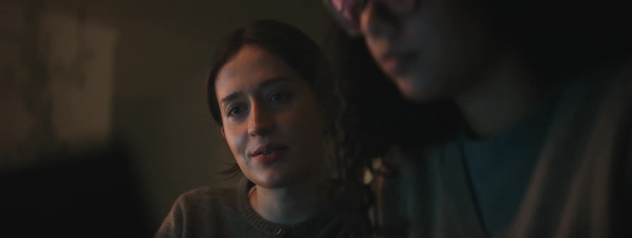 Two young women sitting using a laptop together