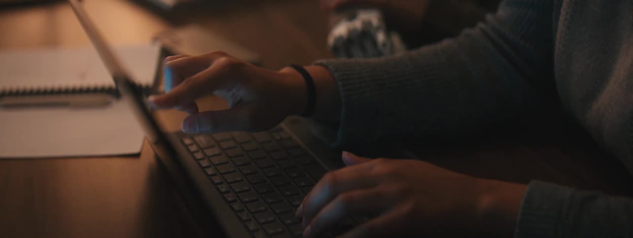 Woman typing on a laptop collaborates with a person with a prosthetic limb
