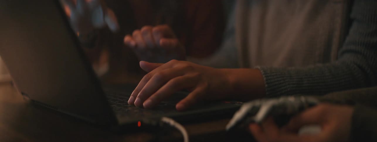 A woman is typing on a laptop