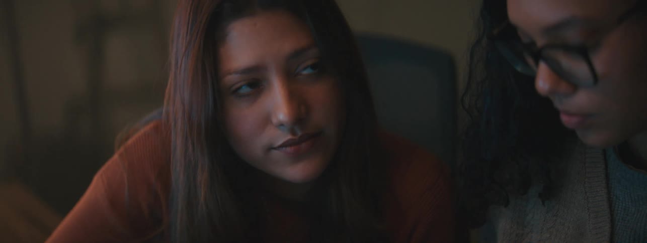 Two women sit in a room and have a discussion