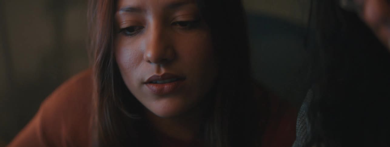 A woman is leaning forward and talking