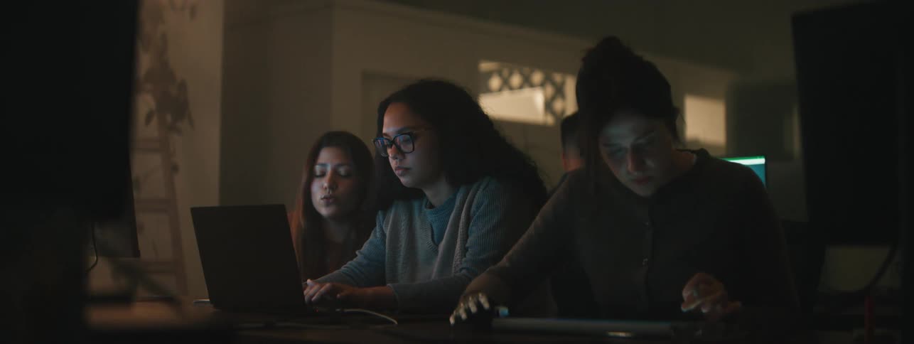 Women at a table using a laptop and a tablet