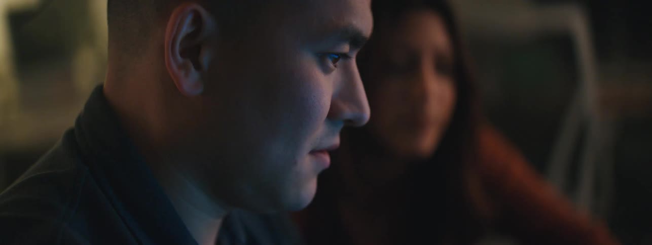 A man and a woman sit in a room and stare