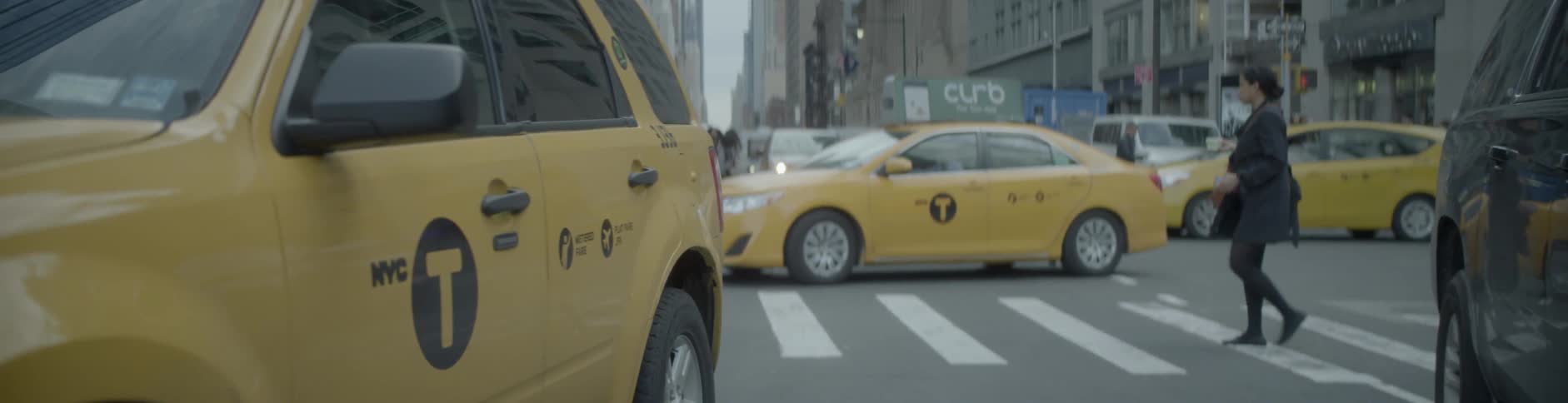 Vehicles and pedestrians occupy a busy city intersection