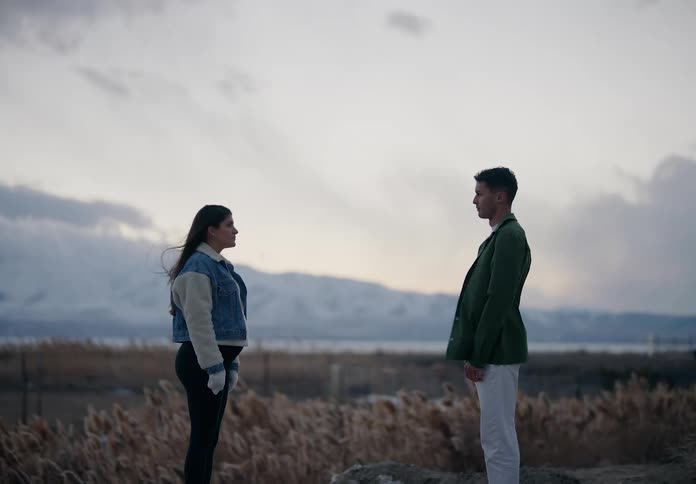 Man and pregnant woman looking at each other face to face in a natural environment