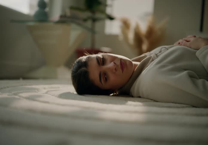 Woman sighs while lying on the rug in her living room