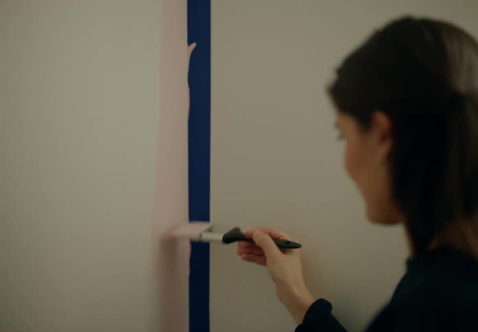 Woman with a paintbrush painting the wall of a room