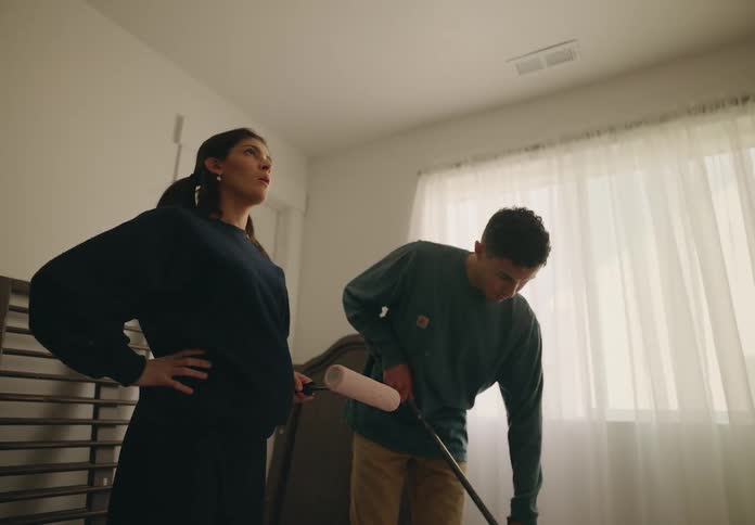 Expectant parents paint the baby nursery