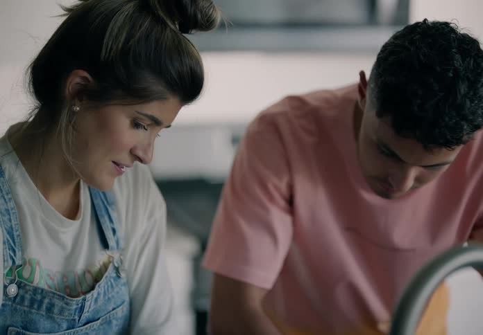 Man and woman lean over a kitchen sink