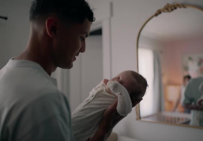 Cheerful father with his baby in his hands in a room