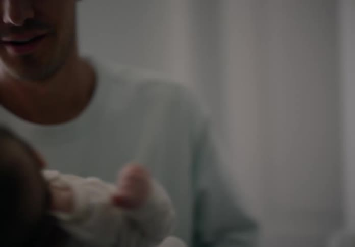 Father picking up a newborn baby and giving him a kiss