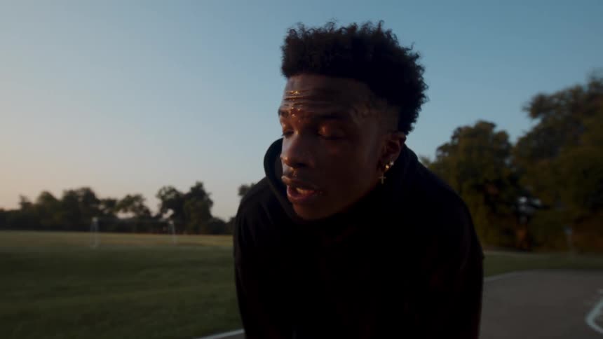 Portrait of a sweaty young man while standing on a court in a field