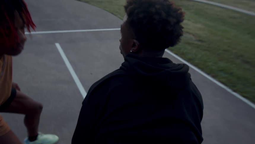 Two young men playing basketball one on one in a park