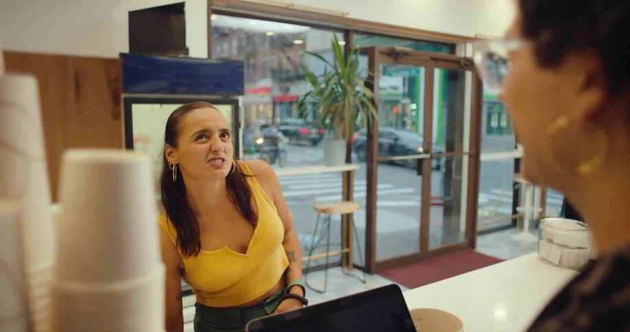 A woman walking dogs enters a coffee shop to buy a beverage